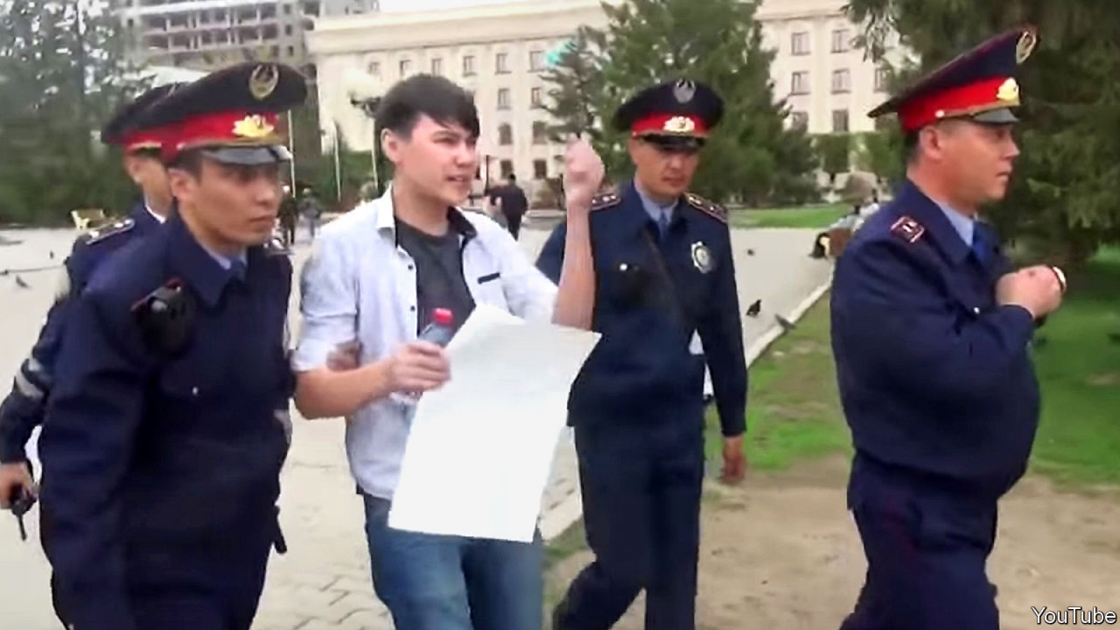 A man holding up a blank placard is arrested