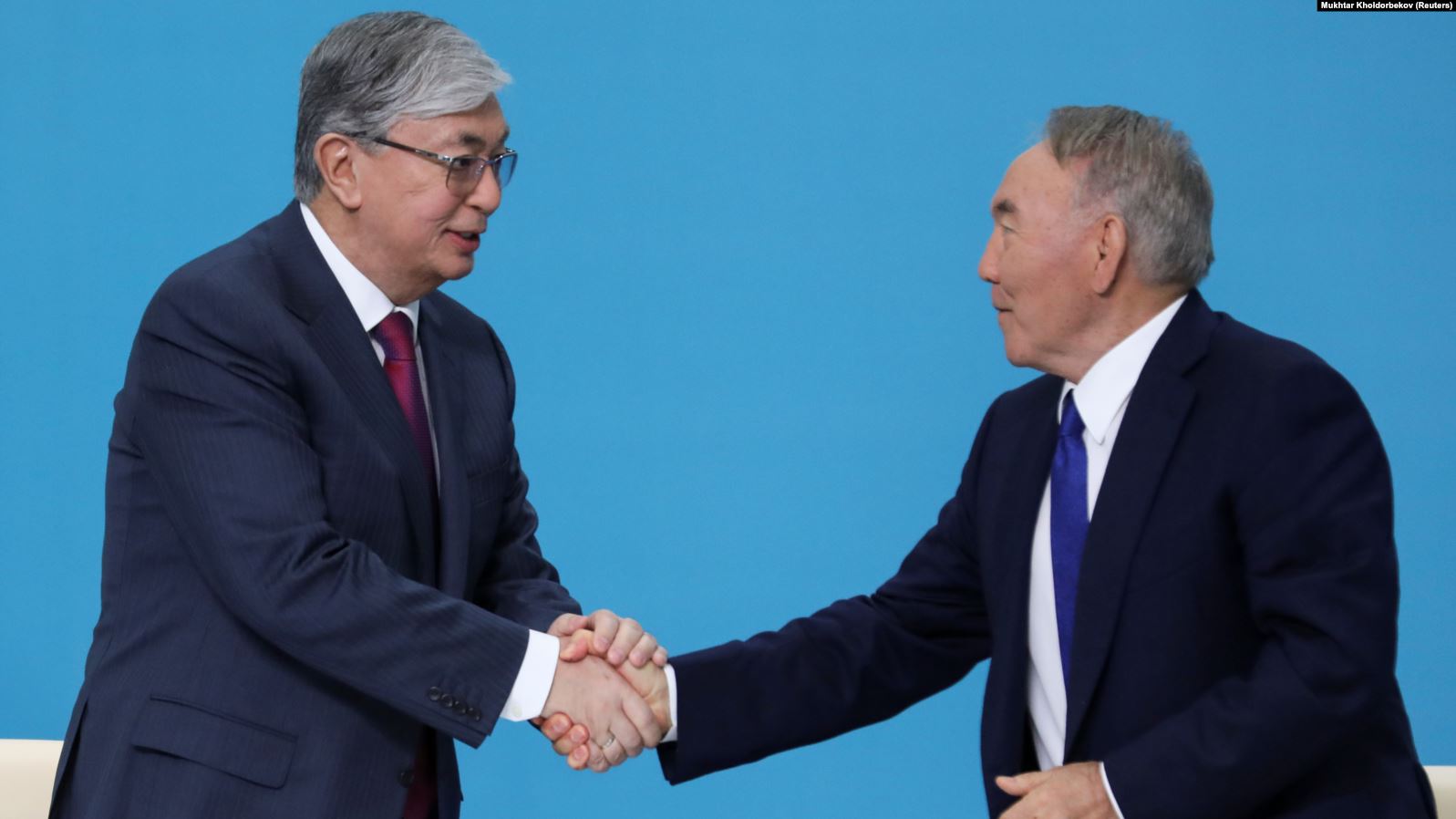 Kazakh interim President Qasym-Zhomart Toqaev (left) and former President Nursultan Nazarbaev shake hands at the congress of the ruling Nur Otan ruling party in Nur-Sultan on April 23.